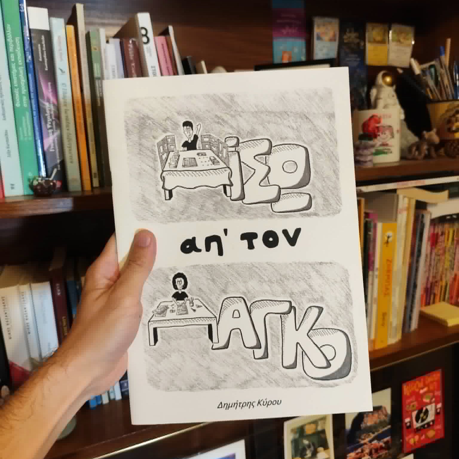 "Πίσω απ' τον Πάγκο" comic book held in hand for size reference.