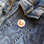 Cat-me If You Can illustrated pin button attached to a denim jacket.