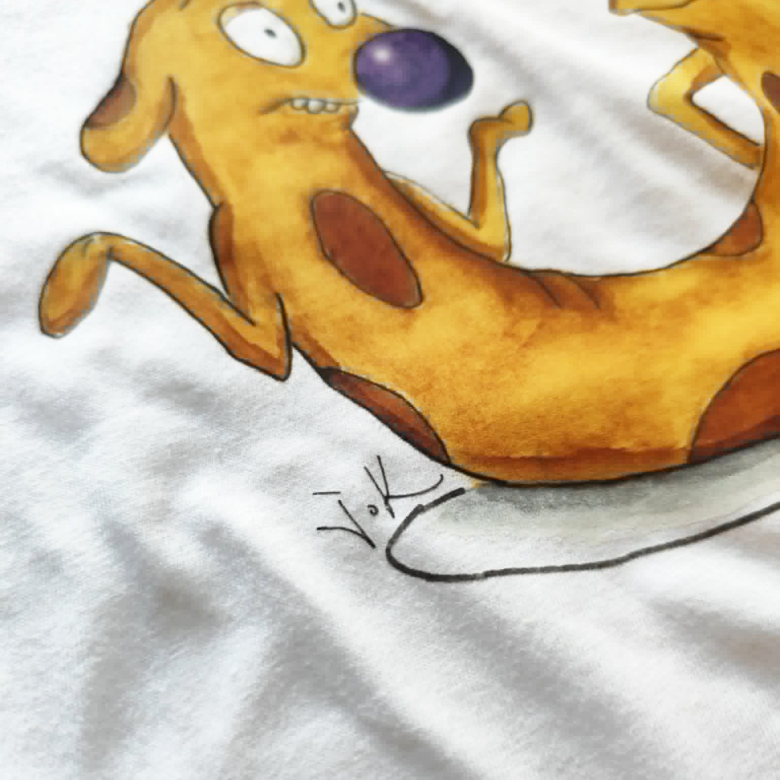 Close-up of the hand-drawn "Cat-ch me if you can" illustration printed on a white unisex t-shirt.