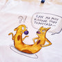 Close-up of the hand-drawn "Cat-ch me if you can" illustration printed on a white unisex t-shirt.
