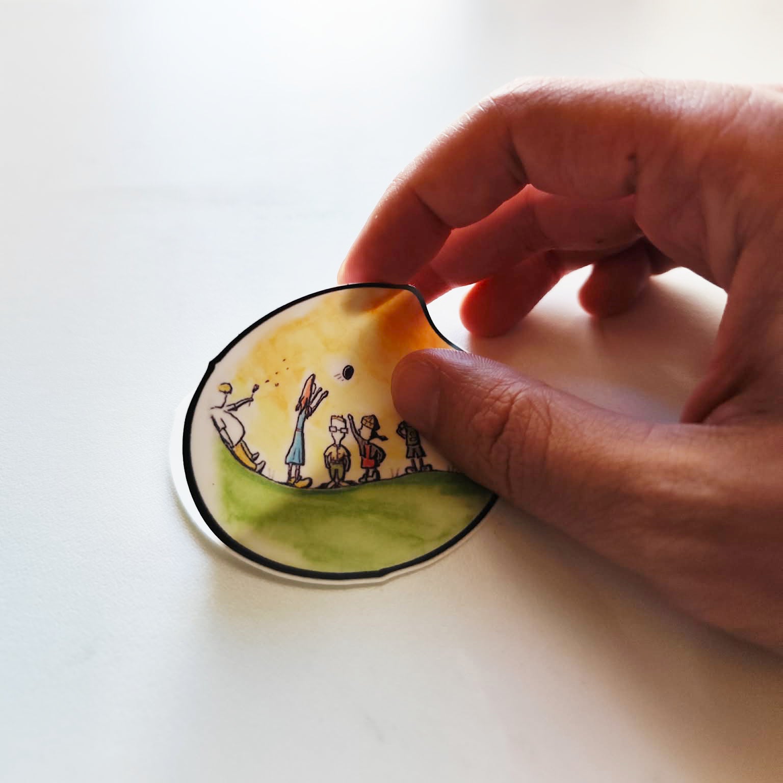 Hand applying Childhood Days illustrated vinyl sticker.