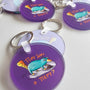Close-up of the Exhausted Spy acrylic keychain by Sketch Stories.