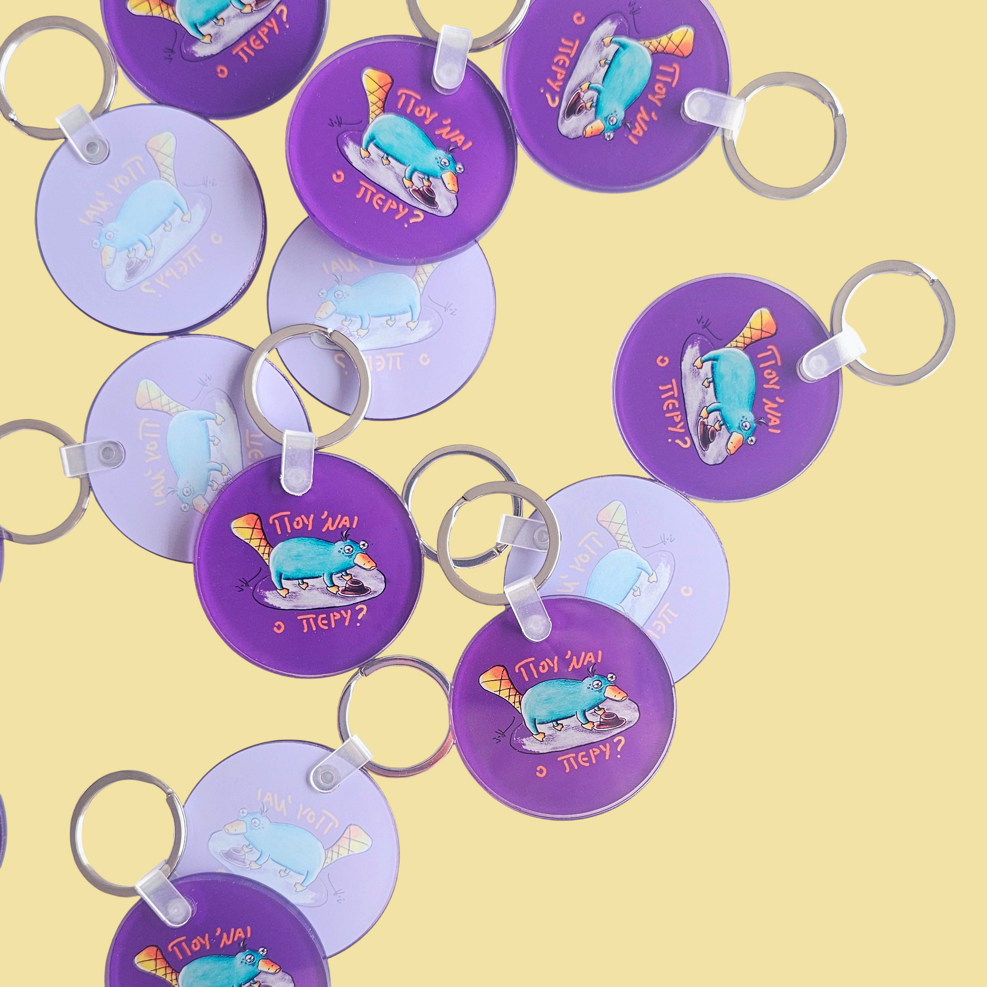 Flat lay of Exhausted Spy acrylic keychains by Sketch Stories.
