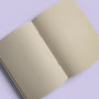 Open Exhausted Spy notebook showing blank cream pages.