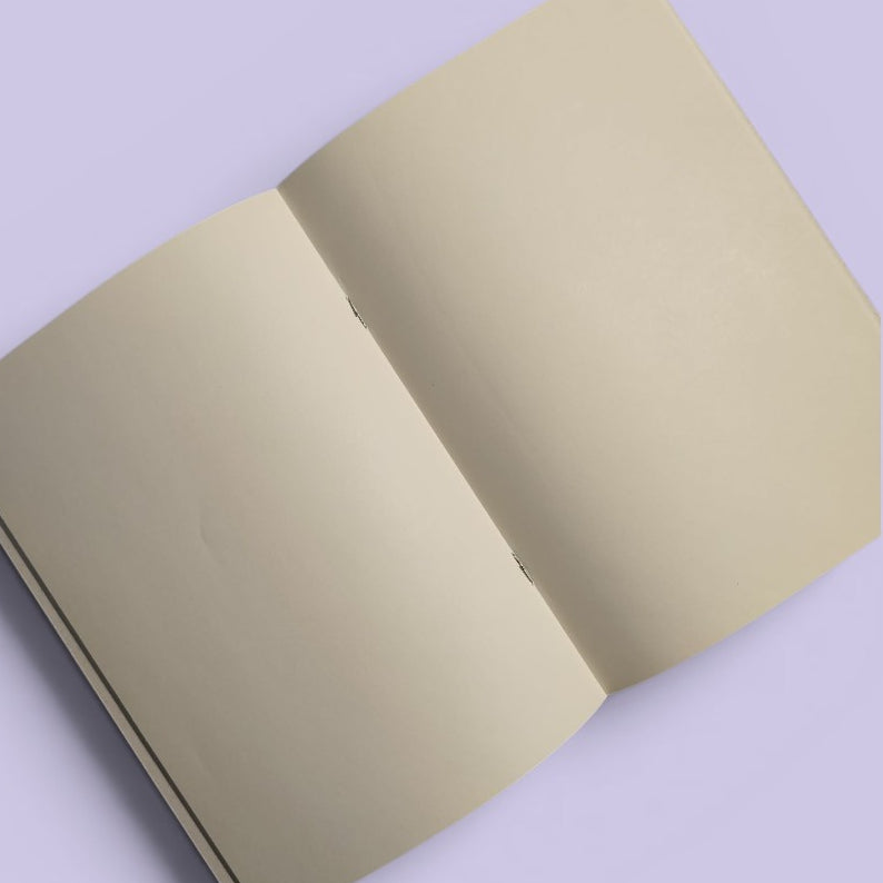 Open Exhausted Spy notebook showing blank cream pages.