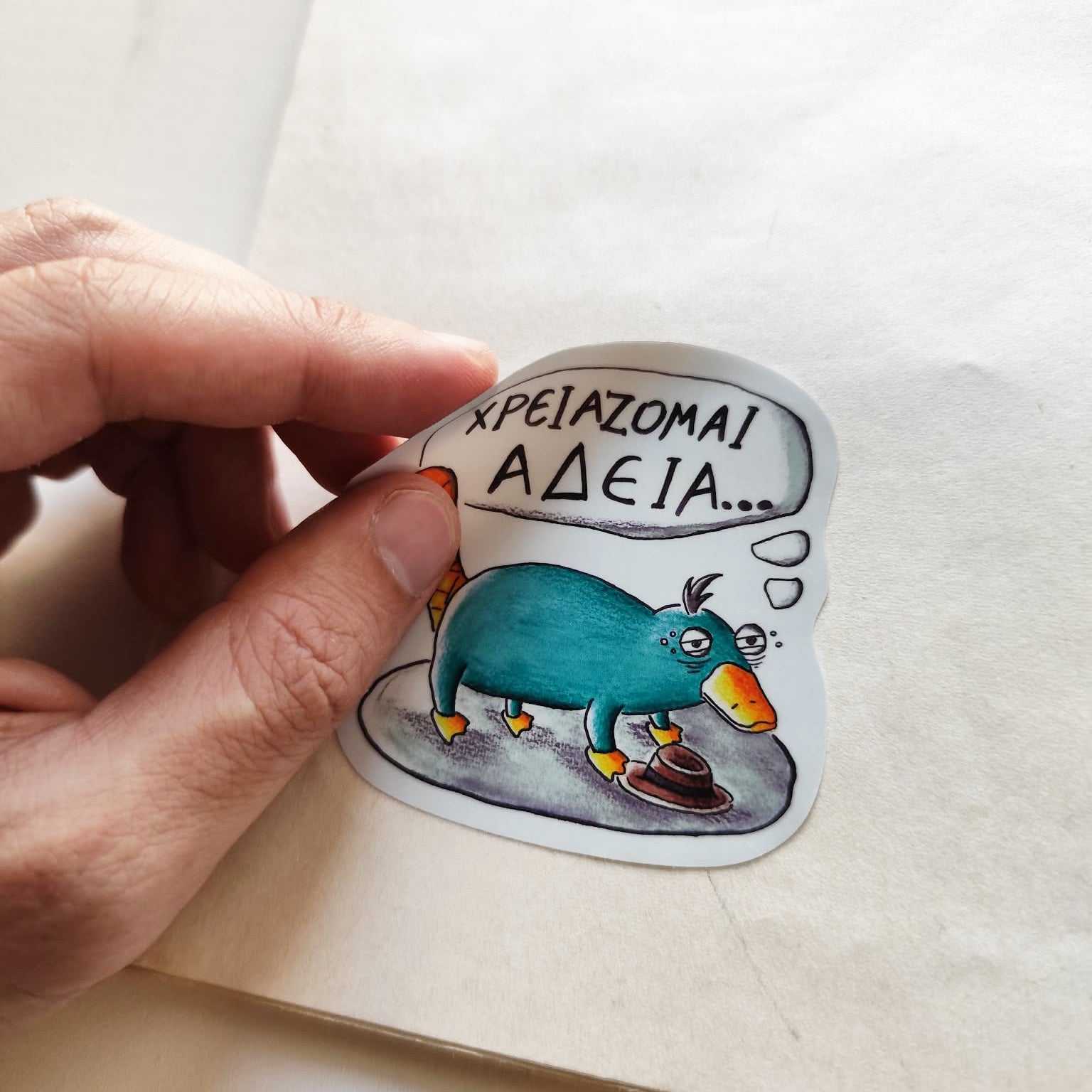 Hand applying Exhausted Spy illustrated vinyl sticker.