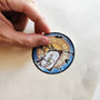 Hand applying Never Grow Up illustrated vinyl sticker.