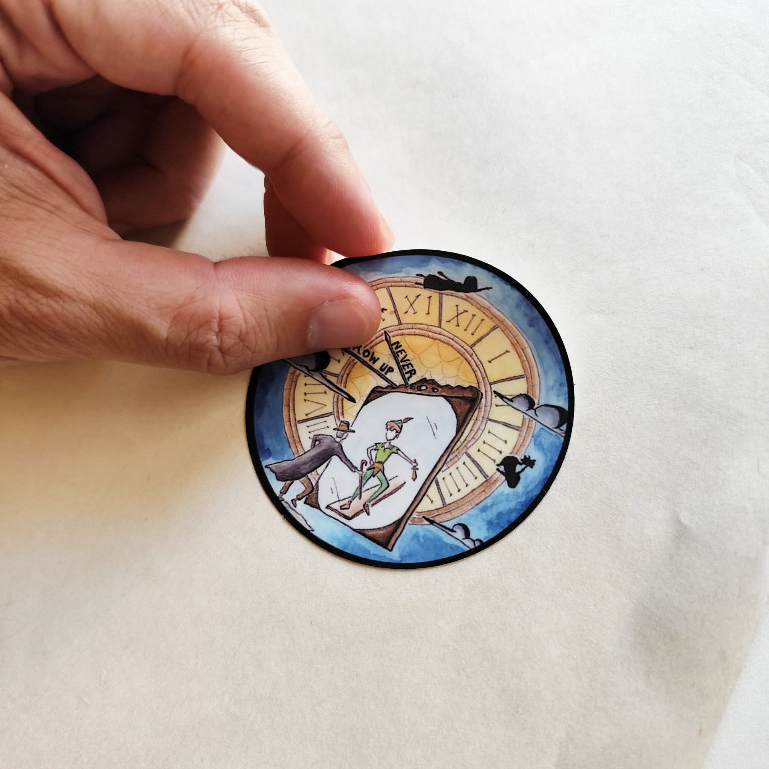 Hand applying Never Grow Up illustrated vinyl sticker.