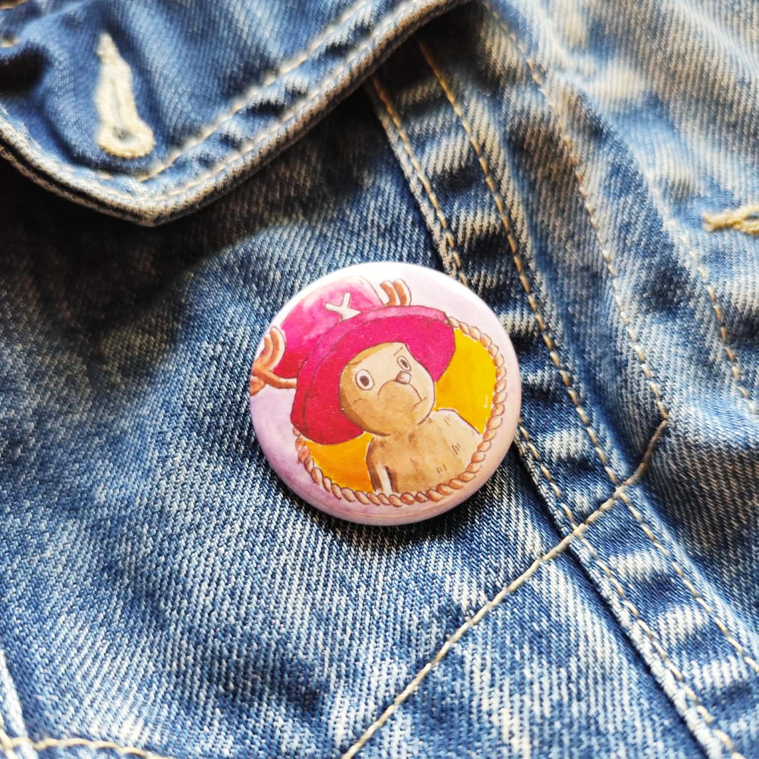 Reindeer Companion illustrated pin button attached to a denim jacket.