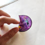Hand applying Sunset Dance illustrated vinyl sticker.